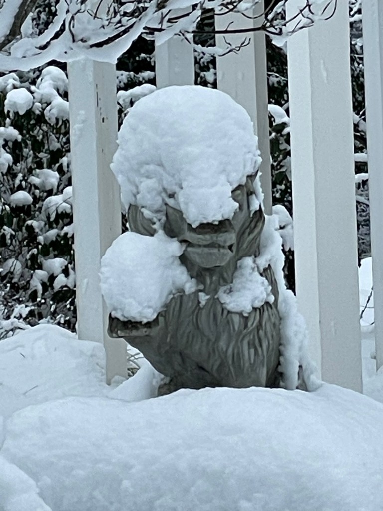 lion statue nearly covered by snow