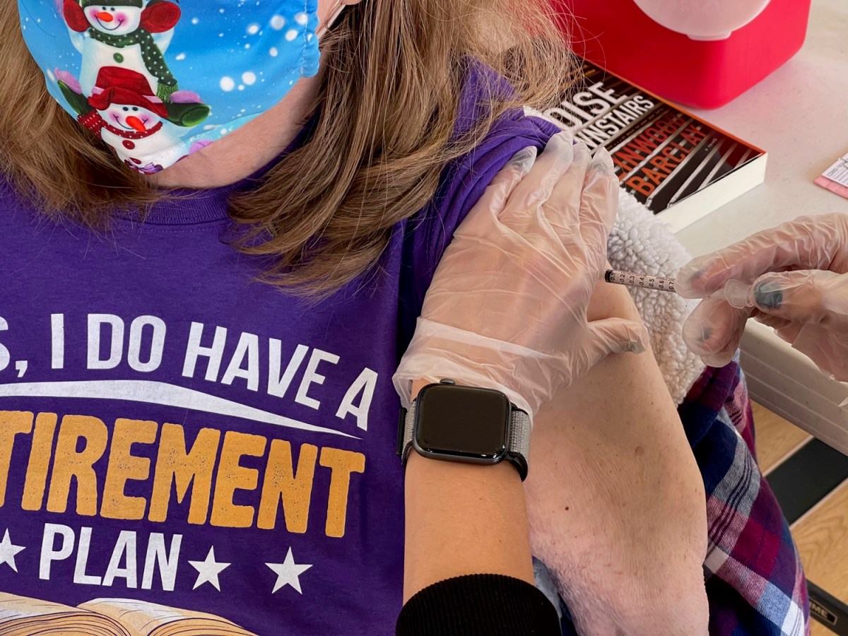 woman receiving vaccination in left arm